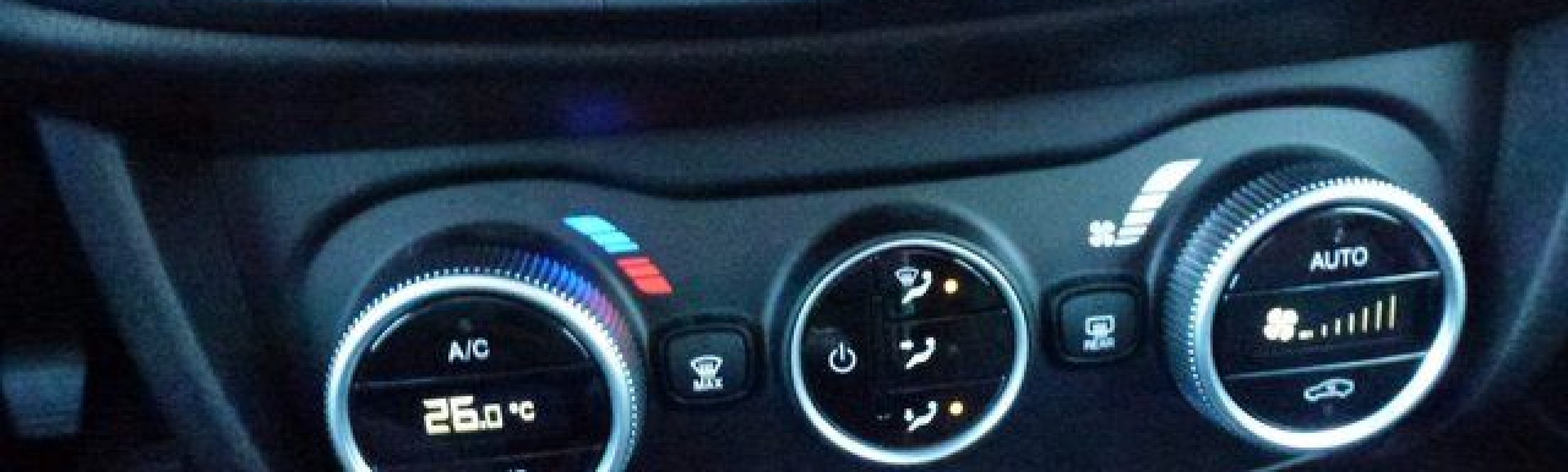 Nahaufnahme des Klimabedienteils eines FIAT Tipo Kombi mit den drei Haupteinstellrädern für Temperatur, Gebläsedrehzahl und Luftstrom sowie den Tasten für die Klimaanlage (Klimaauto), die Warnblinkanlage und andere Funktionen oberhalb der Einstellräder beim Modell 1.6 Multijet.